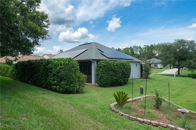 view of home's exterior featuring solar panels and a yard