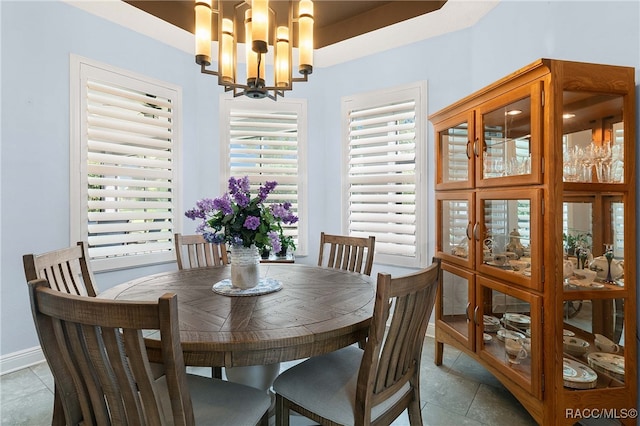 tiled dining space with a chandelier