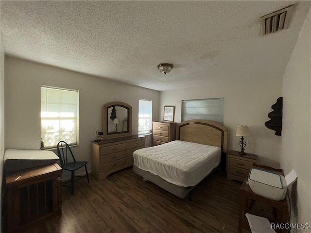 bedroom with dark hardwood / wood-style flooring and a textured ceiling