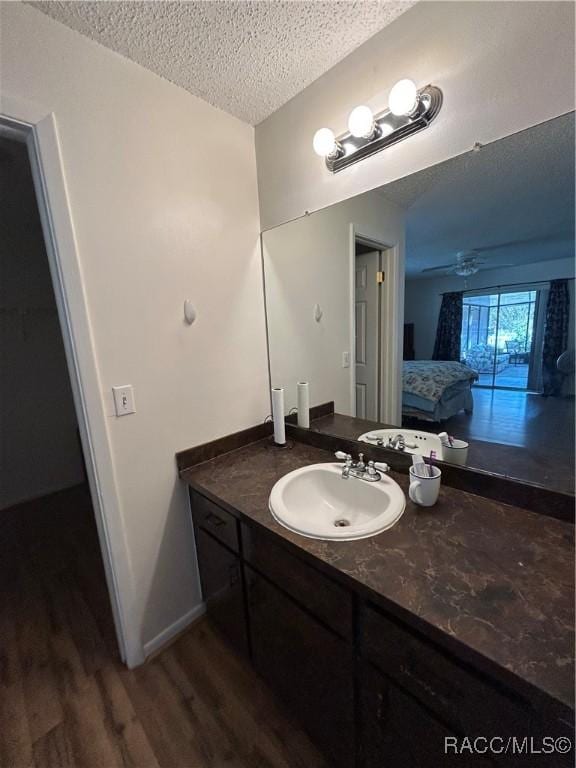 bathroom featuring hardwood / wood-style floors, vanity, and a textured ceiling