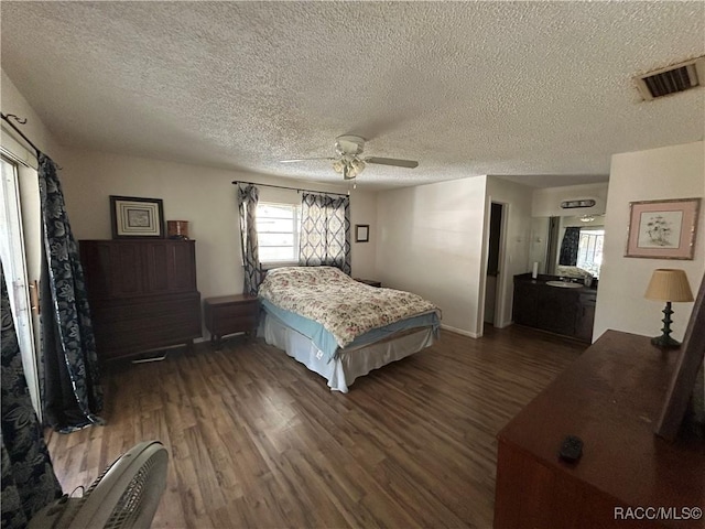 bedroom with a textured ceiling, ceiling fan, and dark wood-type flooring