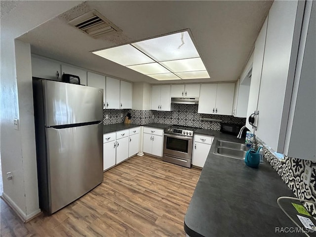 kitchen with backsplash, white cabinets, sink, light hardwood / wood-style floors, and stainless steel appliances