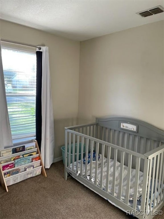 bedroom featuring carpet floors and a nursery area