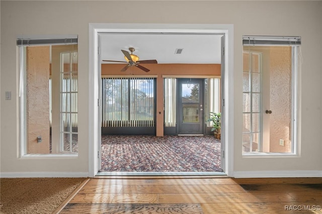 entryway with ceiling fan, visible vents, baseboards, and wood finished floors