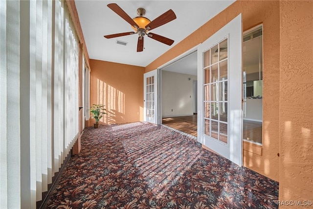 interior space with a ceiling fan, french doors, and visible vents