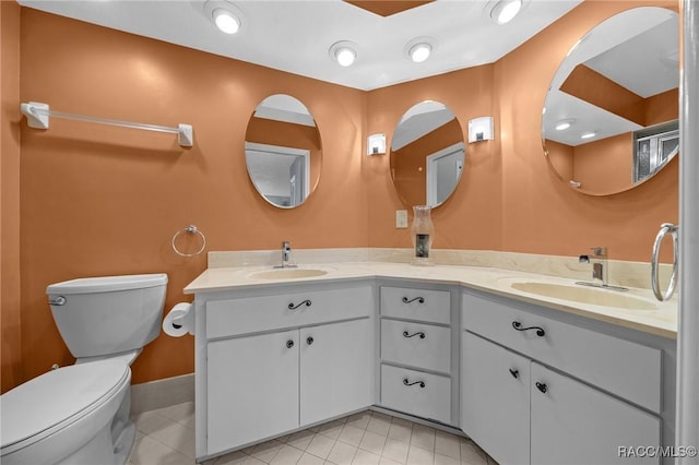 bathroom featuring toilet, a sink, and tile patterned floors