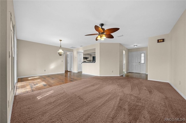 unfurnished living room featuring ceiling fan, carpet, visible vents, and baseboards