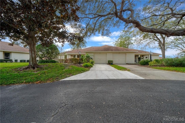 ranch-style house with a garage, driveway, and stucco siding