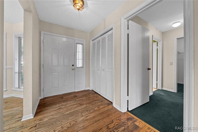 foyer entrance featuring baseboards and wood finished floors