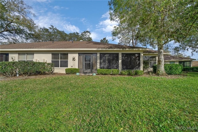 ranch-style home with a front yard and stucco siding