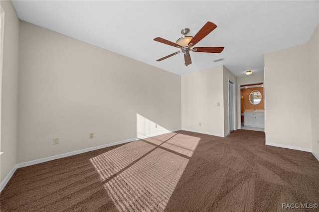 empty room featuring carpet floors, visible vents, baseboards, and a ceiling fan