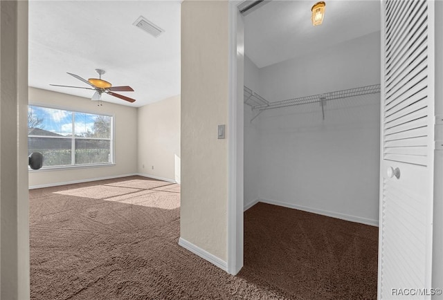 spacious closet featuring carpet, visible vents, and a ceiling fan