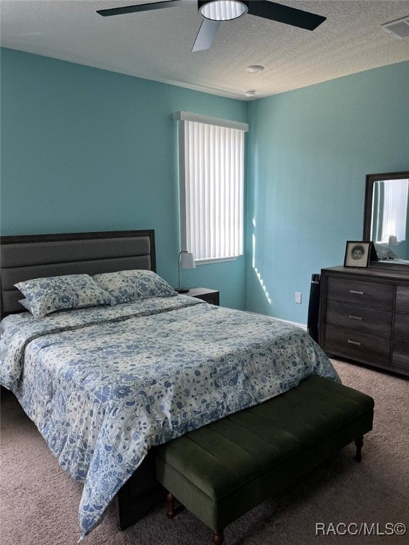 bedroom featuring ceiling fan, carpet, and a textured ceiling