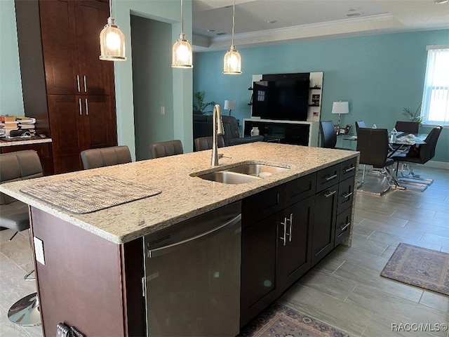 kitchen with stainless steel dishwasher, a kitchen bar, sink, and an island with sink