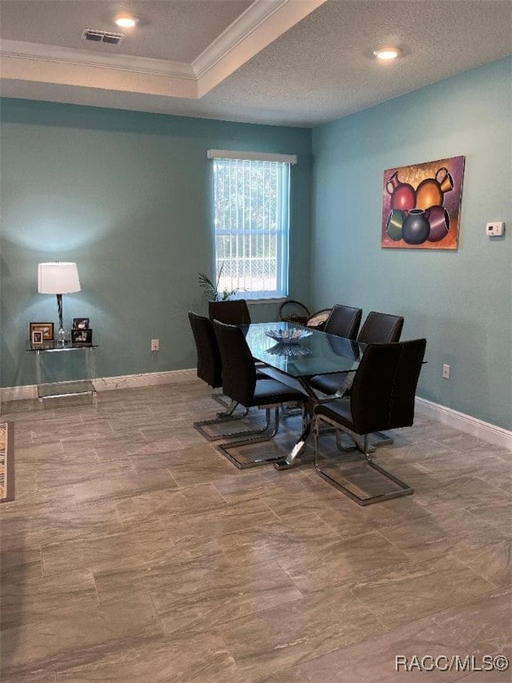 dining area featuring crown molding and a textured ceiling