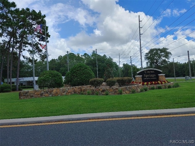 community sign featuring a lawn