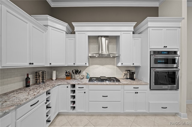 kitchen featuring wall chimney range hood, crown molding, appliances with stainless steel finishes, and tasteful backsplash