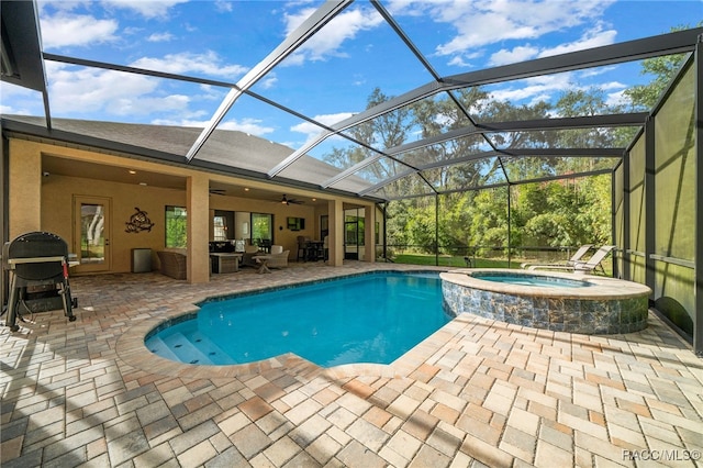 view of pool featuring outdoor lounge area, glass enclosure, ceiling fan, an in ground hot tub, and a patio