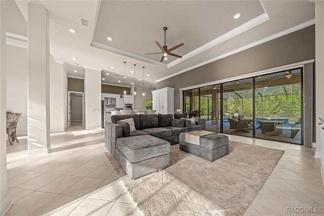 living room with a raised ceiling, light tile patterned floors, and crown molding