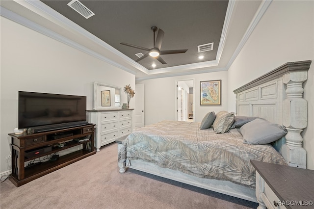 carpeted bedroom with ceiling fan, ornamental molding, and a tray ceiling