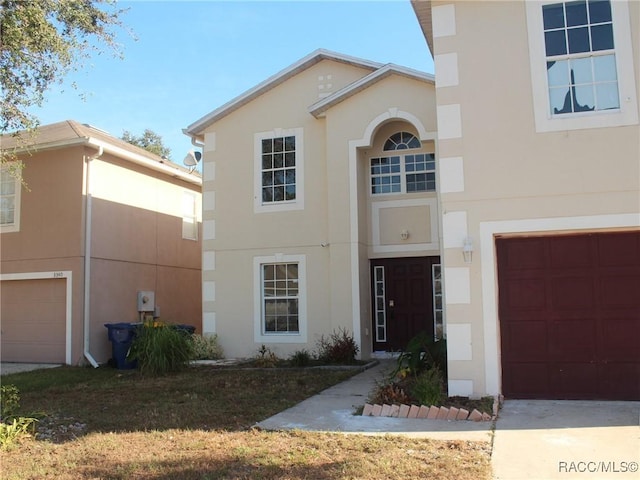 view of front facade featuring a garage, concrete driveway, and stucco siding