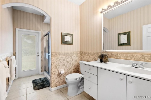 bathroom featuring vanity, tile patterned floors, toilet, and walk in shower