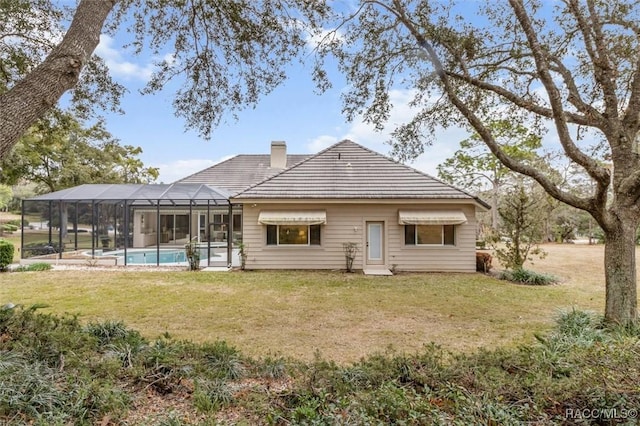 rear view of property with a lanai and a yard