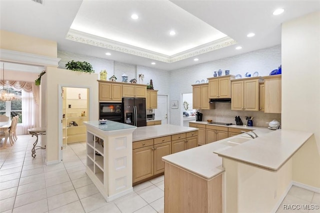 kitchen with a tray ceiling, a center island, kitchen peninsula, and light brown cabinetry