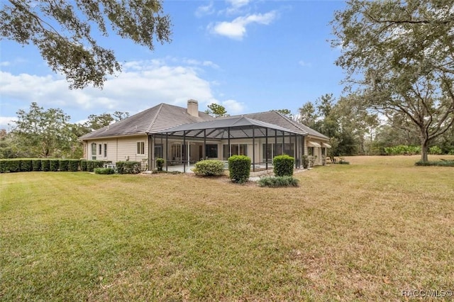 back of house with a lanai and a lawn