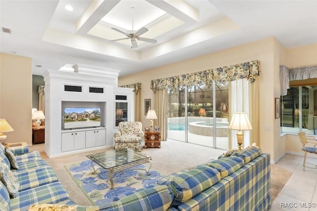 living room with ceiling fan and a tray ceiling