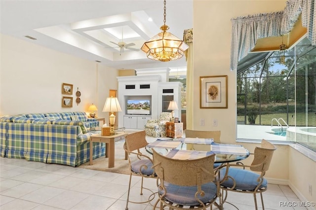 dining space featuring a towering ceiling, light tile patterned floors, ceiling fan, and a tray ceiling