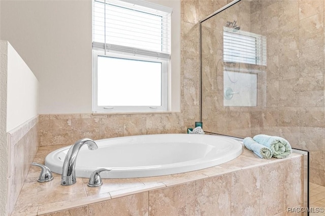 bathroom featuring a garden tub and tiled shower