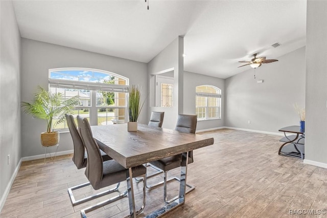 dining area with ceiling fan, visible vents, baseboards, vaulted ceiling, and light wood-type flooring