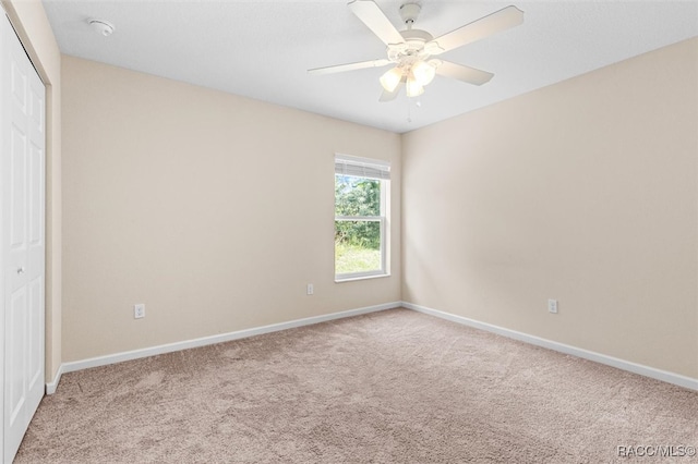 unfurnished bedroom featuring a closet, carpet, a ceiling fan, and baseboards