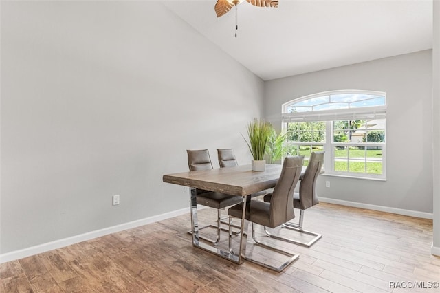 dining area featuring lofted ceiling, ceiling fan, wood finished floors, and baseboards