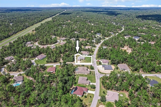 birds eye view of property featuring a view of trees