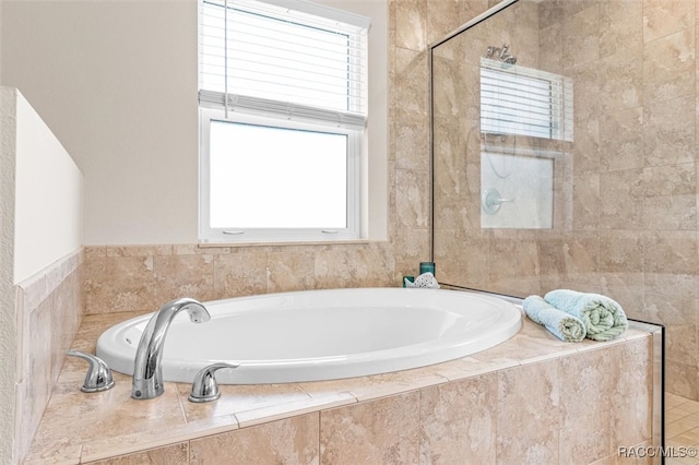 bathroom featuring tiled shower and a bath