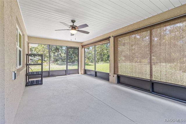 unfurnished sunroom featuring a ceiling fan