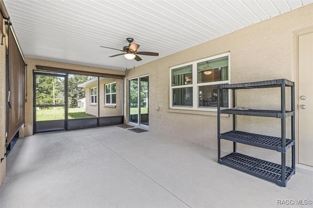 unfurnished sunroom featuring a ceiling fan