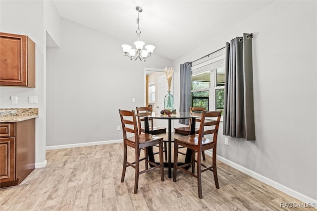 dining area with lofted ceiling, light wood finished floors, baseboards, and a notable chandelier