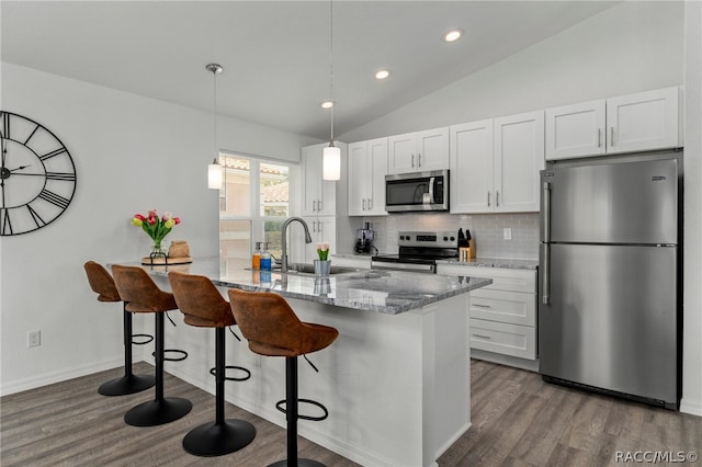 kitchen with kitchen peninsula, stainless steel appliances, white cabinetry, hanging light fixtures, and lofted ceiling