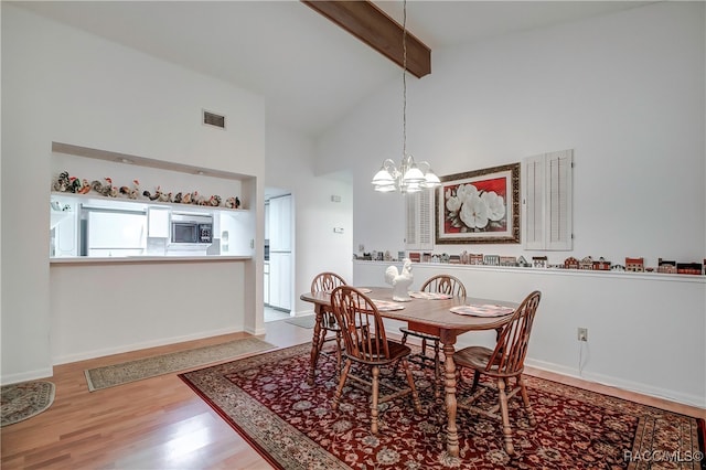 dining area featuring beam ceiling, light wood-type flooring, high vaulted ceiling, and an inviting chandelier