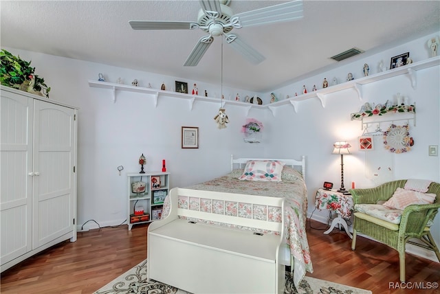 bedroom featuring hardwood / wood-style floors, a textured ceiling, and ceiling fan