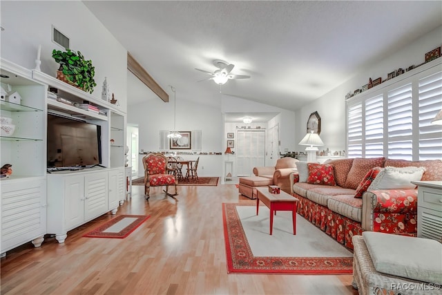 living room featuring vaulted ceiling with beams, ceiling fan with notable chandelier, and hardwood / wood-style flooring