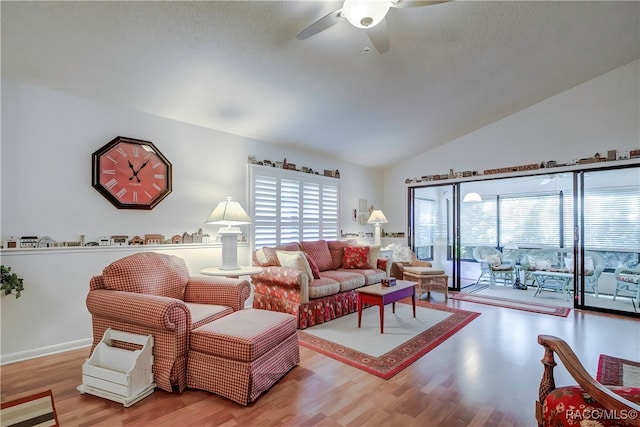 living room with light hardwood / wood-style floors, ceiling fan, and lofted ceiling