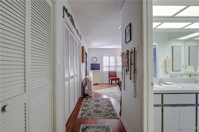 hall with hardwood / wood-style floors and sink