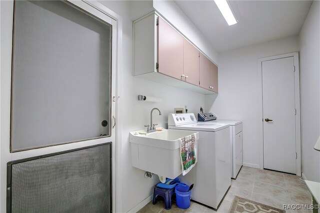 washroom featuring cabinets, sink, and washing machine and clothes dryer