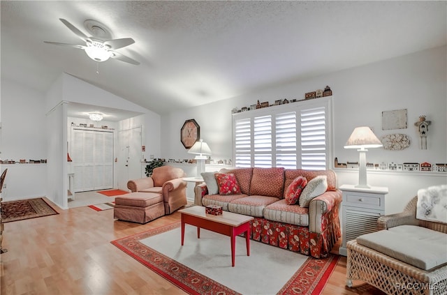 living room with a textured ceiling, ceiling fan, hardwood / wood-style floors, and vaulted ceiling