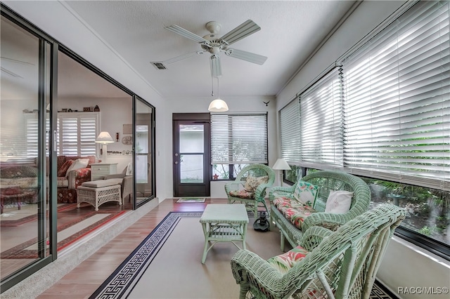 sunroom / solarium featuring plenty of natural light and ceiling fan