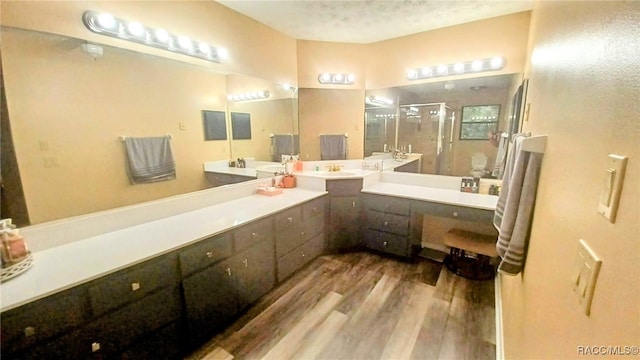 bathroom featuring a textured ceiling, hardwood / wood-style floors, vanity, and an enclosed shower